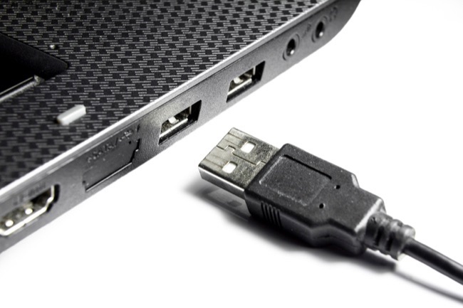 Laptop sa USB konektorima i USB kabelom na bijeloj pozadini