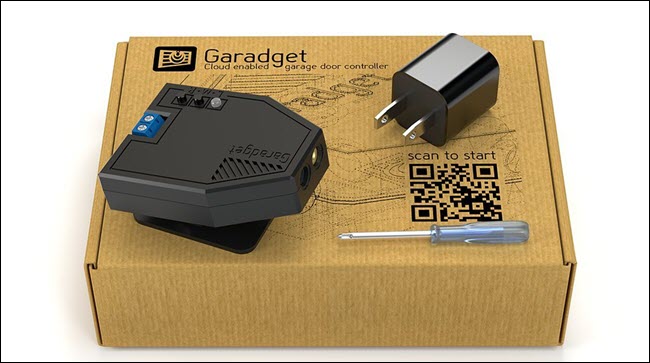 Sensor láser Garadget sentado encima de una caja.